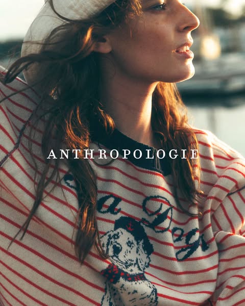 This ad for Anthropologie features a woman wearing a striped sweater with a dog graphic, promoting the brand's cloth