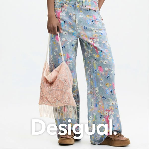 This ad for Desigual features a model wearing floral print pants and a beaded purse.