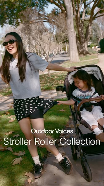 This image ad for Outdoor Voices promotes their Stroller Roller Collection. It features a woman walking outside while pu