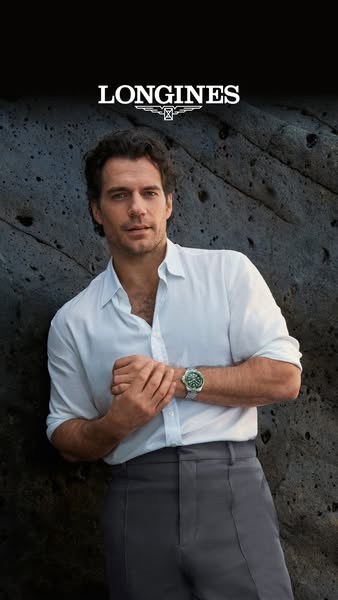 This image ad for Longines features a male model leaning against a textured wall while showcasing a wristwatch. The ad h