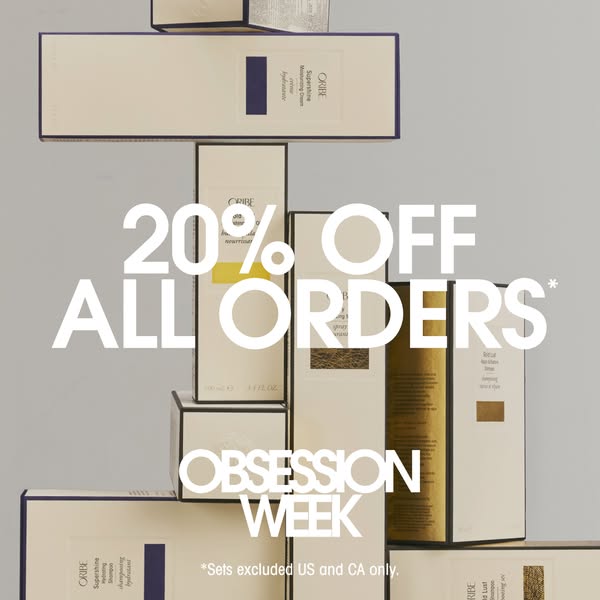 An image ad promoting Oribe hair care products. The ad features a stack of boxed Oribe products, with a large text overl