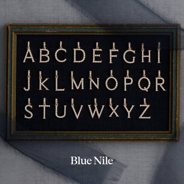 This image ad showcases a collection of alphabet pendants by Blue Nile against a black backdrop inside of a frame.