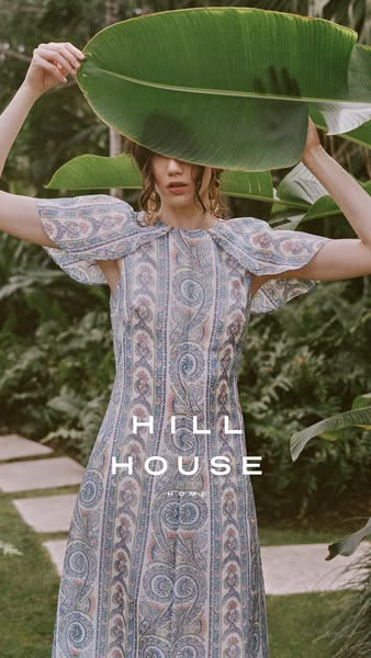 This ad features a woman holding a large leaf in front of her face, wearing a light blue paisley patterned dress. The Hi