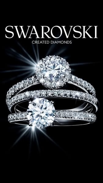 This image ad showcases three rings from Swarovski's Created Diamonds collection. The main focus is on the jewelry, 