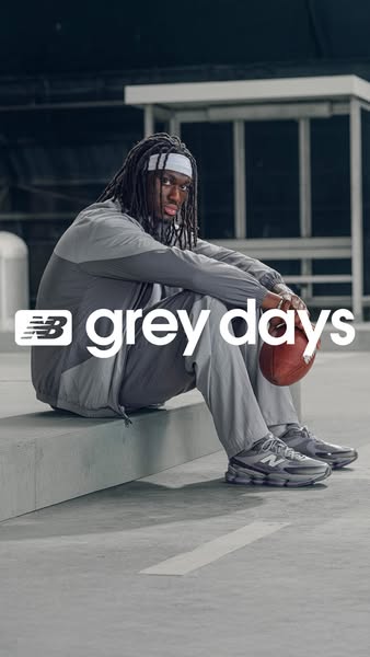 This New Balance ad shows a man sitting, leaning on his hands while holding a football, while also wearing the New Balan