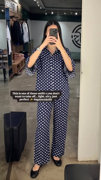 An image ad featuring a woman wearing a navy blue and white polka dot pajama set. A quote from uptownie101 praises the o