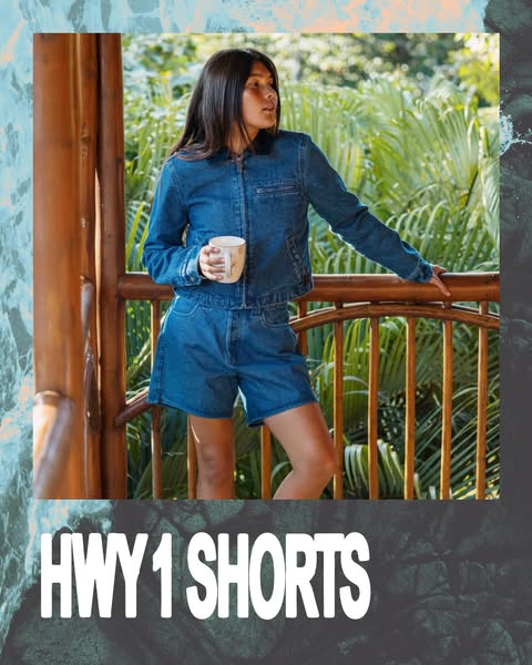 This image ad promotes HWY 1 Shorts. It features a woman in a denim jacket and the HWY 1 Shorts, standing on a wooden ba