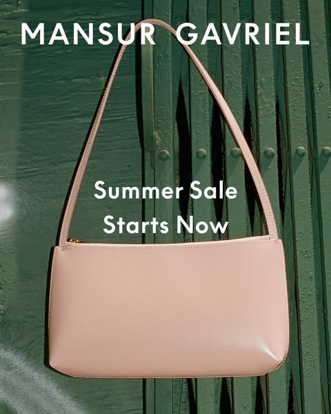 This image ad showcases a single pale pink bag hung against a dark green metal door. The ad announces Mansur Gavriel'