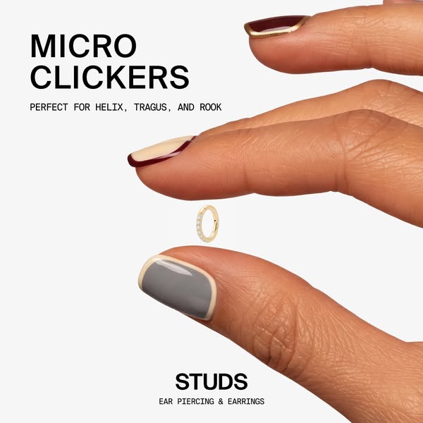 This image ad features a close up of a person's hand showcasing ear piercing jewelry, specifically clickers and stud