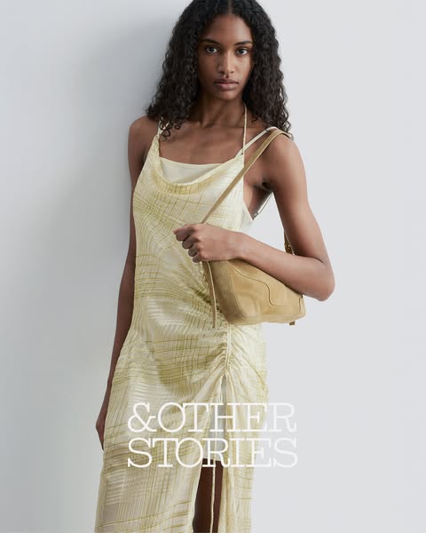 An image ad for & Other Stories featuring a model in a dress and holding a purse.