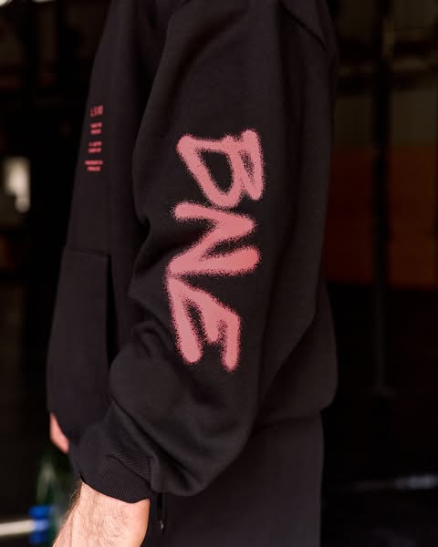 This ad features a person wearing a black hoodie with a spray-painted graphic on the sleeve. The focus is on the aesthet