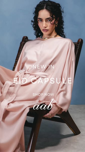 This image ad features a woman sitting in a chair wearing a peach-colored dress from the Aab Eid Capsule collection. The