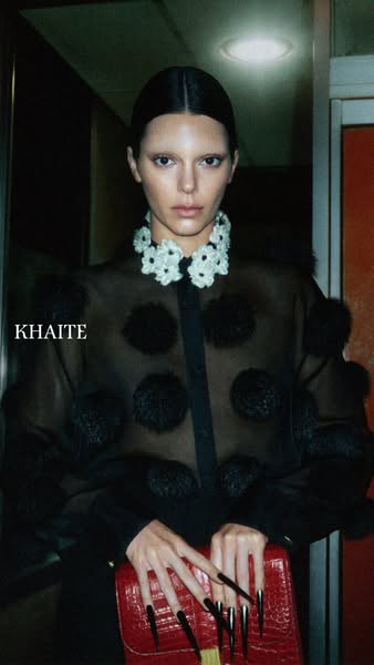 An image of Kendall Jenner modeling a look from the brand Khaite, including a red clutch.