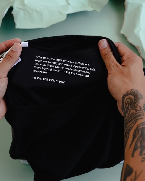 This ad features a black t-shirt with a white text block on the front. The text emphasizes embracing challenges, balanci