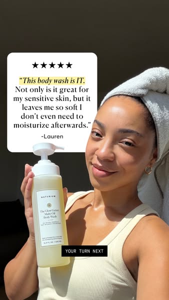 This ad features a woman with a towel wrapped around her head holding Naturium's The Glow Getter Multi Oil Body Wash