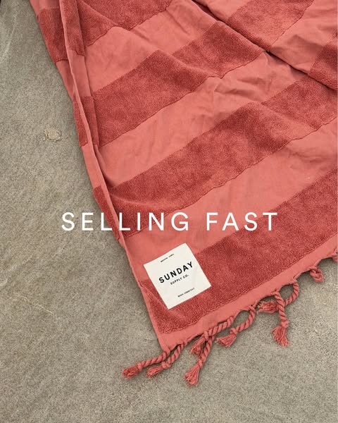 This ad features a close-up shot of a striped towel on a gray stone surface with the words "SELLING FAST" over