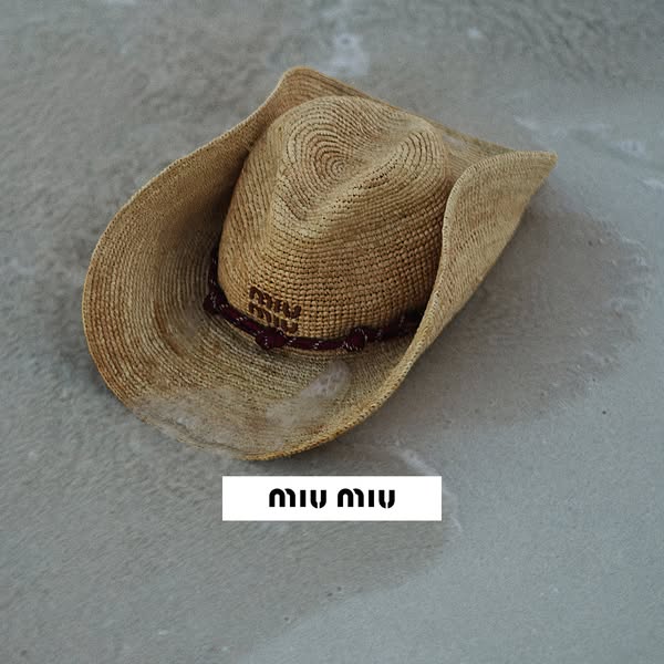 This ad showcases a Miu Miu straw cowboy hat on what appears to be a concrete or stone-like surface.