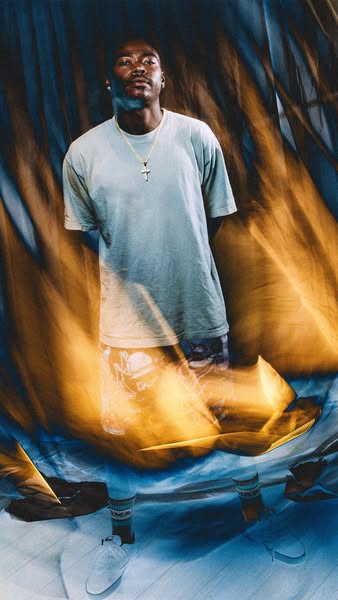 The image ad features a male model in a blue shirt, shorts, white sneakers and socks. He is standing against a blue and 