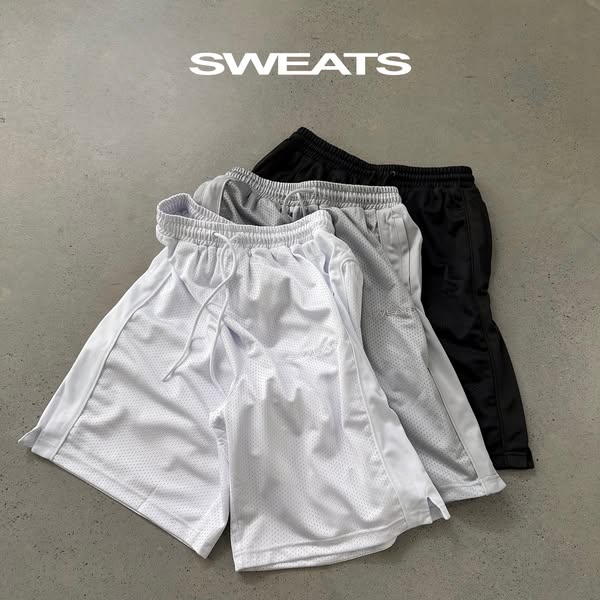 This ad features three pairs of mesh basketball shorts in white, gray, and black. The shorts are arranged on a gray surf