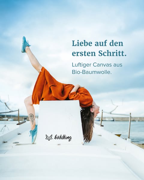 An advertisement for Wildling shoes featuring a woman wearing a pair of the brand's shoes and performing yoga on a b