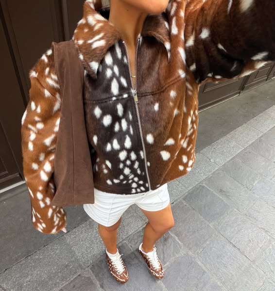 This ad features a woman in an outdoor setting wearing a fur jacket, a pair of sneakers, and carrying a bag, all featuri