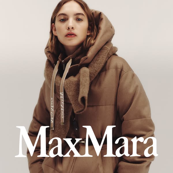 This ad features a woman wearing a tan, hooded jacket with a scarf from the brand Max Mara. The ad showcases the brand&#