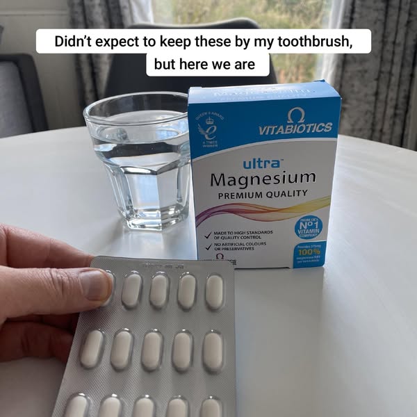 Image ad for Vitabiotics ultra Magnesium Premium Quality. It is displayed along with a glass of water and a hand holding