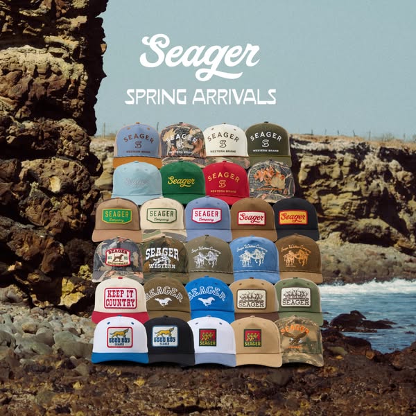 This image ad showcases an array of baseball caps from the brand Seager, set against a backdrop of coastal rock formatio