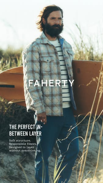 This Faherty image ad showcases a man standing on a beach, holding a surfboard, wearing the brand's outerwear. The a