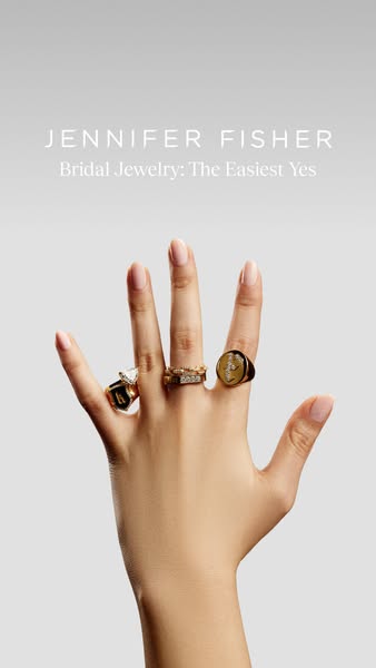 This ad showcases Jennifer Fisher's bridal jewelry collection. The ad displays a woman's hand adorned with a var