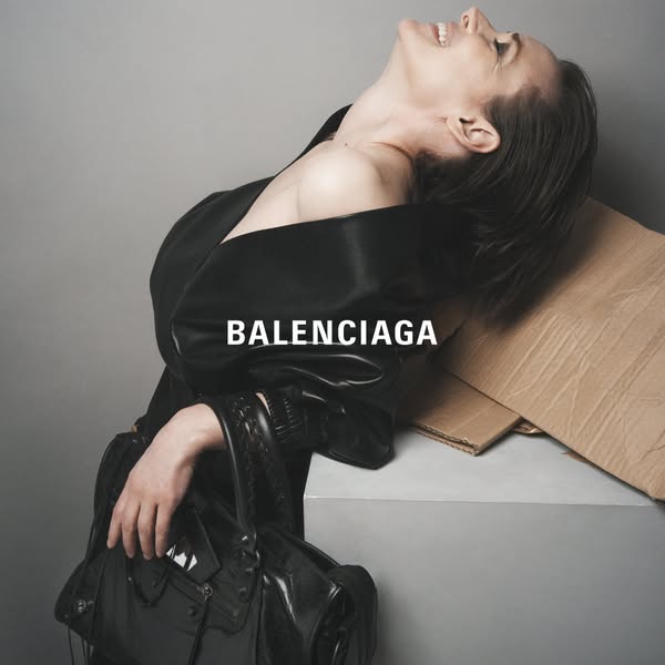 This ad features an elegant, moody shot of a model wearing a Balenciaga jacket and holding a Balenciaga handbag. The ima
