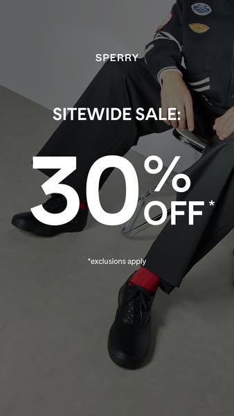 This image ad for Sperry features a model sitting on a stool wearing black Sperry shoes with the promotional text 'S