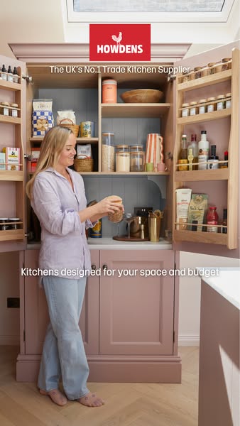 An image ad for Howdens features a woman in a kitchen designed by the brand.