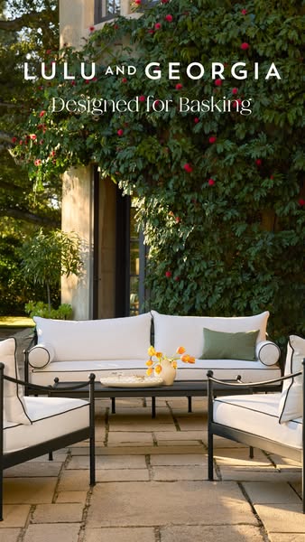 This image ad showcases outdoor furniture from Lulu and Georgia. The scene is set on a stone patio, with a flowering vin