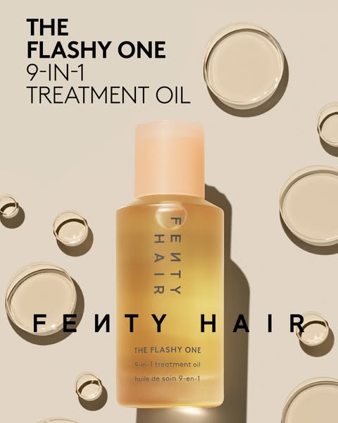 This image ad for Fenty Hair features The Flashy One 9-in-1 Treatment Oil. The ad showcases the product bottle with floa