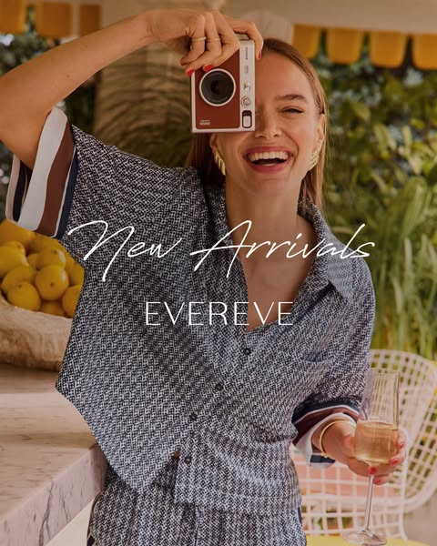 This ad for Evereve features a woman holding a camera up to her face and smiling while holding a champagne glass in the 