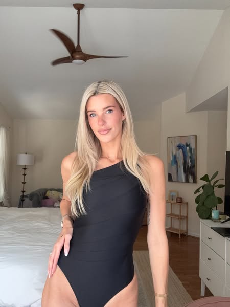 This ad features a real-life woman in her home modeling a black, one-shoulder bathing suit. The ad promotes the look of 