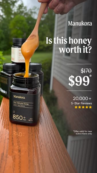 This image ad for Manukora honey features a wooden spoon pouring honey into a jar of Manukora Raw Mānuka Honey. The ad h
