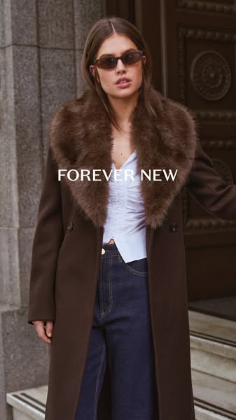 This ad for Forever New showcases a woman wearing a brown coat with a fur collar and dark jeans. The ad aims to promote 