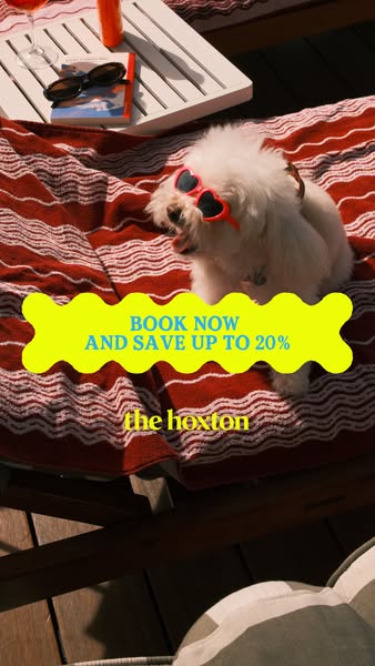 An ad for The Hoxton hotel showing a cute white dog on a red and white striped beach towel wearing heart-shaped sunglass