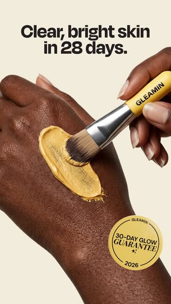 This image ad showcases a person's hand applying a Gleamin skincare product with a brush, promising clearer and brig