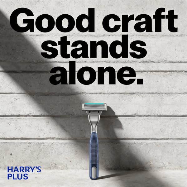 This ad for Harry's Plus features a razor with a blue handle against a concrete wall. The ad headline is 'Good c