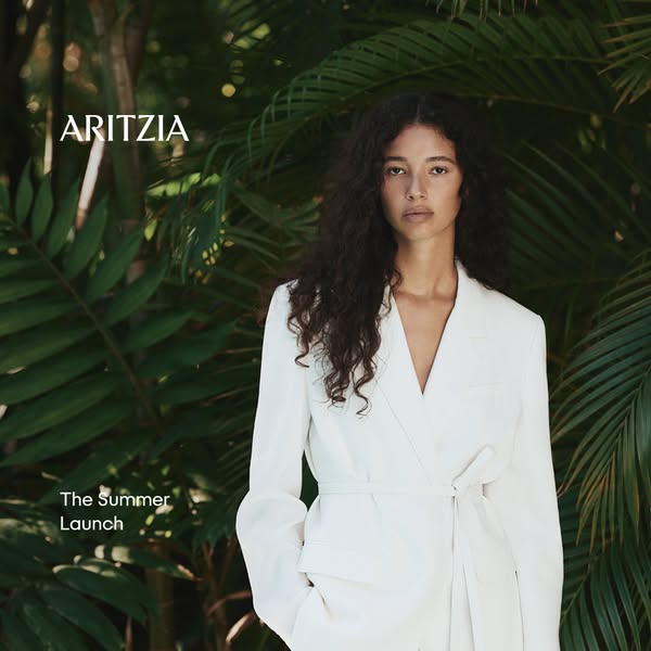 This ad for Aritzia showcases a woman in a white wrap blazer. The ad promotes Aritzia's Summer Launch.