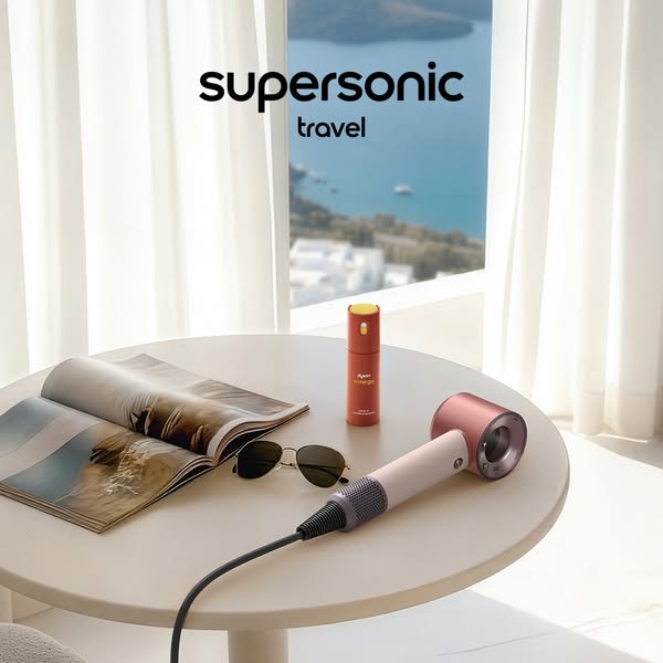 This ad showcases a Dyson Supersonic hair dryer and its travel-sized styling concentrator attachment in a setting that i