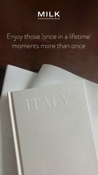 This image ad for MILK Books features a hardcover photo book on a dark wood surface. The ad emphasizes the idea of enjoy