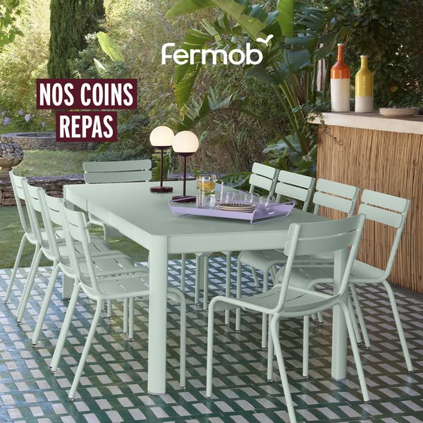 This ad features a stylish outdoor dining set from Fermob, emphasizing the enjoyment of meals in a relaxed, outdoor sett