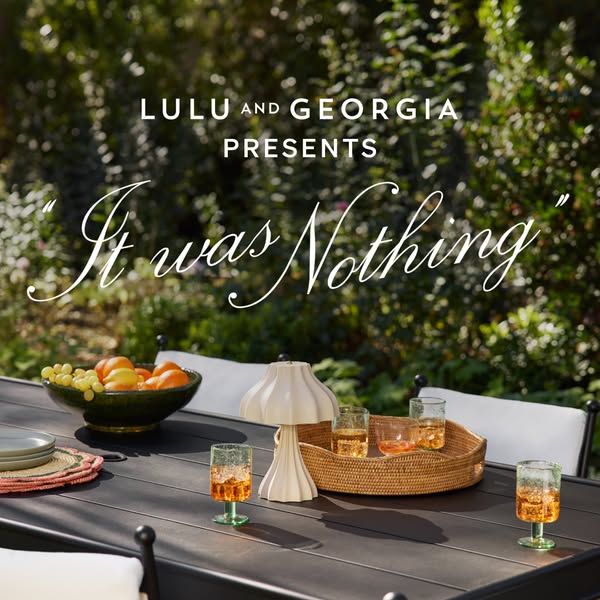 This ad for Lulu and Georgia shows an outdoor tablescape featuring an ivory table lamp, glassware, and other decorative 