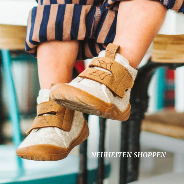 A close up image of baby shoes. The shoes are soft colored and designed for a baby.