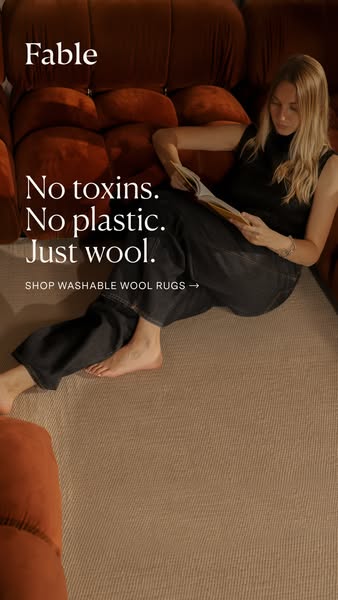 This ad for Fable promotes their washable wool rugs. The ad features a woman relaxing on a rug and couch, emphasizing th