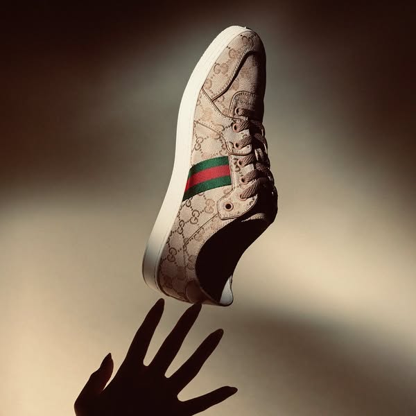 This ad features a single Gucci sneaker and shows it floating above a hand to showcase its design.